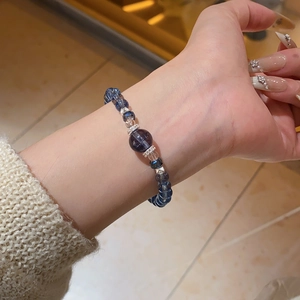 Macro shot of blue zircon crystal beaded elastic bracelet with silver floral spacers
