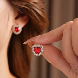 Dettaglio orecchini vintage a cuore con cristallo rosso e diamanti su oro