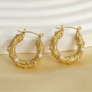 Detail of 18k gold plated hammered earrings with pearls and crystals on satin