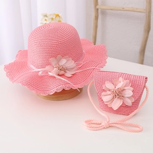 Close-up of pink straw sun hat and matching crossbody bag with floral decorations