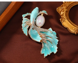 Detail of vintage koi fish brooch with teal enamel, sparkling crystals and large pearl