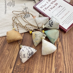 Macro shot of assorted silk Zongzi charms with colorful tassels on a wooden surface