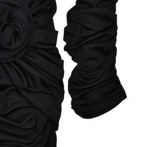 Détail de la fleur 3D et de la texture plissée sur le tissu d'une robe moulante noire