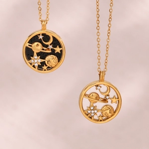 Detailed close-up of golden necklaces featuring black and white celestial coin pendants