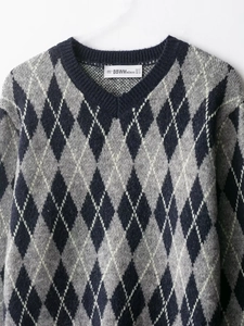 Macro detail of V-neck argyle knit sweater with blue, gray and white diamond pattern