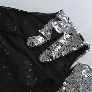 Détail de paillettes argentées sur mesh noir pour une robe de soirée longue licou