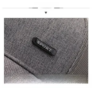 Détail macro du tissu en maille tissée gris foncé avec emblème Sport sur la casquette