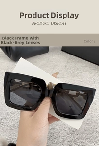 Detalle de gafas de sol cuadradas oversize con montura negra y cadena dorada