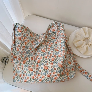 Detail of floral printed cotton tote with orange flowers and seamless shoulder strap