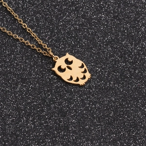 Polished gold owl pendant with hollow laser-cut design on a black shimmering background