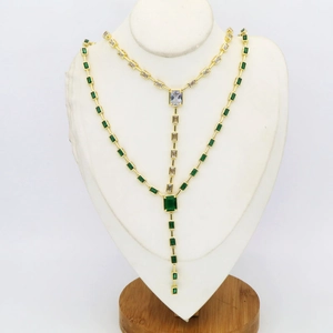 Luxurious gold necklace with emerald green and clear zircon stones in a bamboo link design