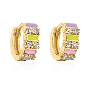 Close-up of golden hoop earrings with colorful enamel stripes and sparkling zircons