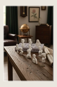 Set of 10 classic miniature white resin busts on a rustic wooden table in a retro study room