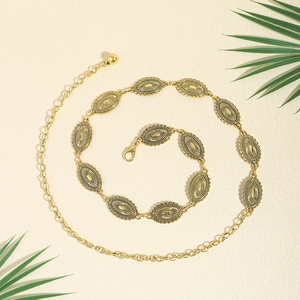 Detailed close-up of vintage bohemian gold metal waist chain with embossed oval link accents