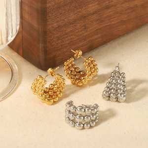 Orecchini a cerchio a C con perline in oro 18K e argento su sfondo in tessuto naturale