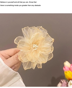 Vue détaillée de la pince à cheveux fleur en organza avec de délicates perles centrales