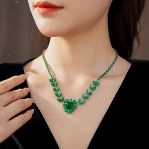 Close-up of green heart zircon necklace with wheat ear design on elegant model