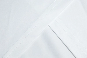 Detailansicht aus nächster Nähe von weißem Stoff mit präziser Doppelnaht und Textur