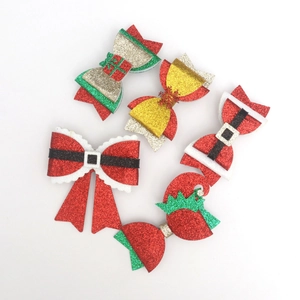 Close-up of glitter Christmas hair clips with festive colors and Santa belt patterns