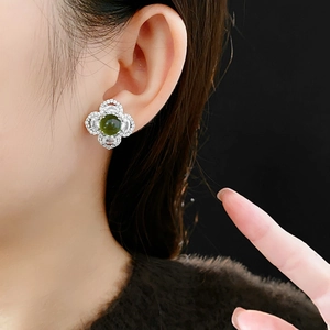 Detail of silver clover stud earring with green gemstone and sparkling zircons
