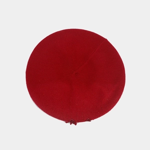 Close-up of red knit beret featuring delicate bead embellishments and fine texture