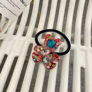 Détail d'élastique à cheveux ours rouge avec cristaux colorés sur cordon élastique