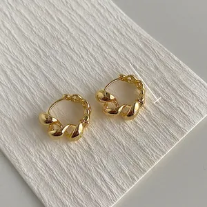 Detail van gedraaide gouden oorringen met afmetingen 1,8 cm diameter en gewicht van 5 g