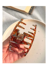 Close-up of a large amber marble acrylic hair claw clip showing texture and strong spring