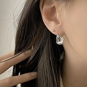 Close-up of irregular molten texture silver earrings on model featuring modern 925 silver design