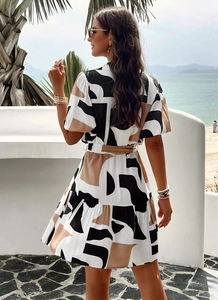 Elegant geometric print short sleeve dress with waist tie and ruffle hem shown from the back