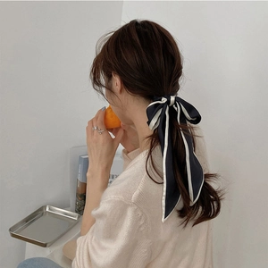 Elegante nastro per capelli nero con bordi bianchi legato a fiocco per uno stile raffinato