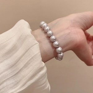 Detail of silver-purple pearl bracelet with elegant luster on a soft fabric background