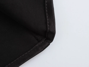 Detail shot of black elegant evening dress fabric texture and professional hem stitching