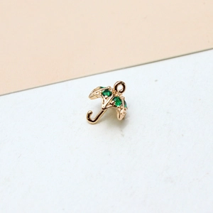 Close-up of gold-plated umbrella pendant featuring inlaid green zircon and a hanging loop