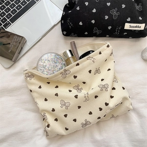 Detail of corduroy makeup bag with bow prints showing spacious interior storage