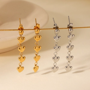 Vue macro de boucles d'oreilles pendantes à cœurs étagés en finitions or et argent poli