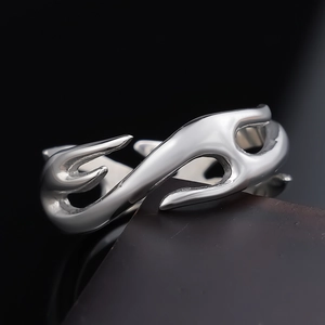 Macro shot of silver punk flame totem ring with metallic fluid wave design details