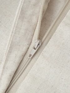 Detail of the high-quality beige zipper and linen fabric texture on a two-piece set