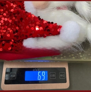 Close-up of red sequin Christmas hat with white plush trim and red braids, weighing 69g