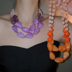 Detail view of double-layered acrylic bead necklace with purple and marble textured charms