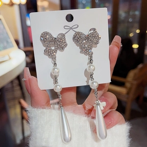 Close-up of S925 silver long tassel earrings with sparkling bow and teardrop pearls