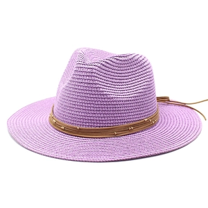 Detail of purple woven straw Panama hat with brown beaded cord and golden accents