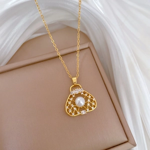 Macro view of gold handbag pendant with white pearl and sparkling crystals on chain