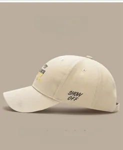 Detail of beige washed cotton baseball cap featuring black SHOW OFF side embroidery