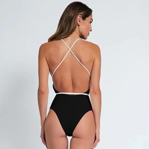Detail of cross straps and deep V open back on black and white one piece swimsuit