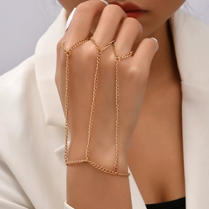Close-up of a gold metal slave bracelet with star and butterfly charms on a female hand