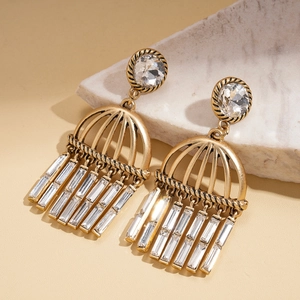 Detail view of vintage gold tassel earrings featuring crystal studs and woven metal frames