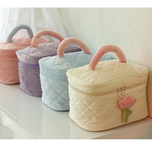 Detailed group view of colorful quilted corduroy makeup bags with floral zipper charms