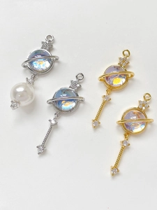 Detail of 14k gold-plated planet pendants with cat-eye stones and zircon for DIY jewelry