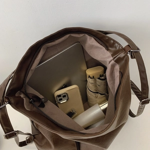 Deep brown faux leather tote bag showing large capacity for laptops and daily essentials